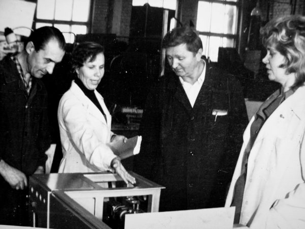 Šaltkalvis V. Nevulis, vadovaujančioji konstruktorė N. Kudrevičienė, cecho viršininkas A. Slušnys ir M. Stonkuvienė prie gaminamo M6-AUD bandomojo pavyzdžio
