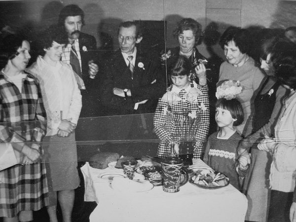 Konstruktorių padengtą stalą pristato N. Kudrevičienė – pirmoji kairėje. Už jos stovi B. Katkauskienė, nežin., K. Augustinas, J. Lenkauskienė, B. Juodagalvienė, L. Sakalauskaitė, mažesnioji mergaitė – Rūta Bernotaitė. 1978 m.