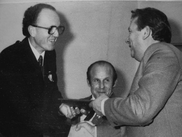 1984 m. spalio 29 d. MPA gamybinio susivienijimo generalinis direktorius J. Šeškevičius 25-mečio sveikinimą perduoda SKB viršininkui V. Mickevičiui