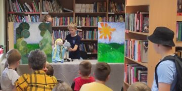 Bibliotekos „Nykštuko Brazduko“ teatro aktoriai Višakio Rūdos bibliotekoje vaidina spektaklį pagal Jurgio Dovydaičio užrašytą lietuvių liaudies pasaką „Našlaitė Elenytė ir Joniukas-aviniukas